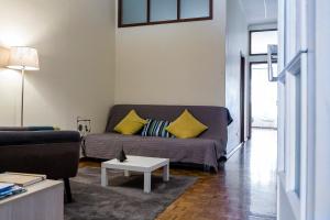 uma sala de estar com um sofá e uma mesa em Downtown Shelter - Casa da Praça em Aveiro