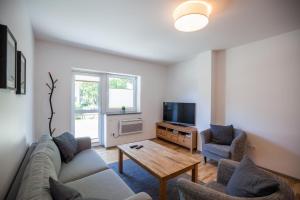 a living room with a couch and a table and a tv at Namelis Preiloje in Neringa
