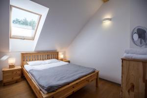 a bedroom with a wooden bed and a window at Namelis Preiloje in Neringa