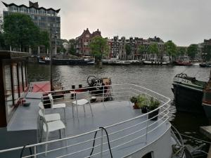 a boat is docked in a river with buildings at houseboat Rose in Amsterdam
