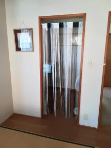 a glass door with a mirror in a room at Jukichi Owada Residence in Sendai