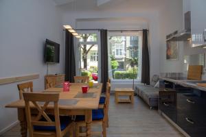 Pandoras home في برلين: مطبخ وغرفة معيشة مع طاولة وأريكة