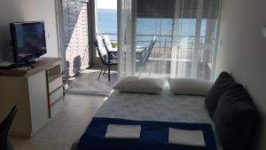 Cette chambre comprend un lit, une télévision et un balcon. dans l'établissement Apartments Bilobrk, à Trogir