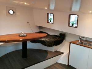 a kitchen with a table and a sink in a room at houseboat Rose in Amsterdam