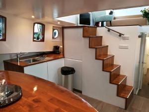 a kitchen with a spiral staircase in a tiny house at houseboat Rose in Amsterdam +30 photos
