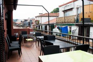 a patio with tables and chairs on a balcony at Pensión San Fermín in San Sebastián