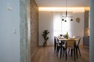 a dining room and living room with a table and chairs at SingularStays Sorolla in Valencia