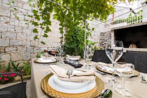 a table with glasses and napkins on a patio at Apartment Stari Dvor in Kaštela