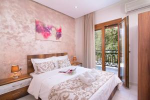 a bedroom with a white bed with a balcony at Pension Maria in Astris