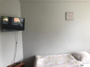 a flat screen tv hanging on a wall above a bed at Pokoje gościnne Zuzanna Krupa in Kluszkowce