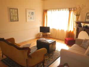 een woonkamer met een bank en een tv bij Yarram Cottage: Art and Accommodation in Yarram