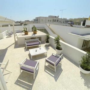 d'une terrasse sur le toit avec des chaises et des tables. dans l'établissement B&B PALAZZO MARZO, à Otrante