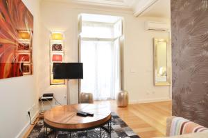 sala de estar con mesa y TV en Chiado Luxury Experience - Checkinhome, en Lisboa