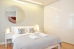 リスボンにあるChiado Luxury Experience - Checkinhomeのベッドルーム1室(壁に鏡付きのベッド1台付)
