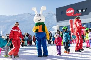 Un gruppo di persone in piedi nella neve con un costume da coniglio. di Ausblick a Blatten bei Naters