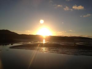 a sunset over the ocean with the sun in the sky at Shimaotoya in Iriomote