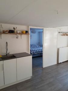 a kitchen with a sink and a room with a bed at Unieke stadswoning voor 2 personen met Finse sauna in Apeldoorn
