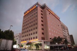 a tall building with a sign on top of it at Al Azhar Hotel Jeddah in Jeddah