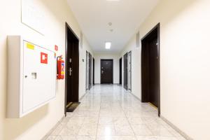 シフィノウイシチェにあるApartamenty Stella Baltic by Rentersの黒いドアとタイル張りの床の廊下