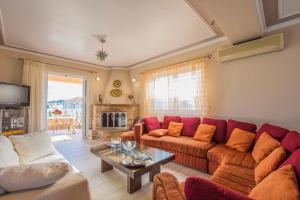 a living room with a red couch and a table at Zante View (4bedroom luxury home) Free Pickup in Zakynthos Town