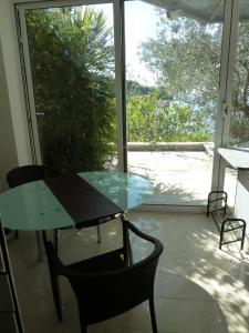 szklany stół i krzesło przed oknem w obiekcie Apartment direkt am Strand w Okrugu Gornjim