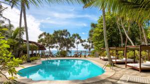 una piscina in un resort con palme di Good Karma a Tangalle