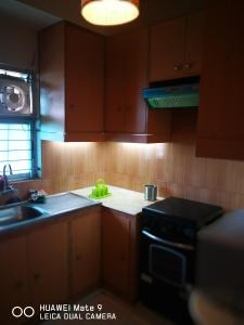 a kitchen with wooden cabinets and a sink and a stove at Rajanigandha Family Suites in Dhaka