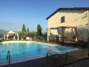 a swimming pool in front of a building with a house at Il Poggio del Sole in Montefalco