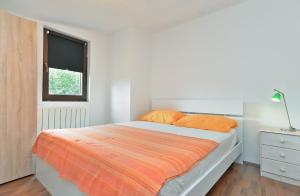 - une chambre blanche avec un lit et une couverture orange dans l'établissement Apartments Dragica 929, à Fažana