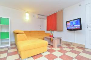 - un salon avec un canapé et une télévision dans l'établissement Apartments Dragica 929, à Fažana