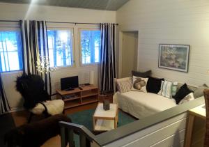 a living room with a couch and a chair at Lomakylä Atimo in Alakitka