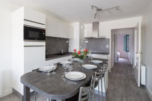 a kitchen with a table with plates and wine glasses at Au Quai Des Pecheurs by Cocoonr in Saint Malo