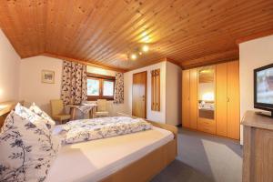 1 dormitorio con 1 cama grande y techo de madera en Pension Hauser, en Sankt Jakob in Haus