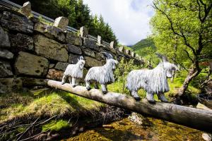 a statue of three goats on a stone wall at Byrkjedalstunet Hotell in Byrkjedal