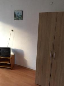 a small television sitting on a wooden stand next to a cabinet at Къща за гости Шотарови in Dospat