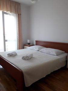 una camera da letto con un letto e due asciugamani di Apartments Merica a Novalja (Novaglia)