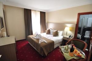 a hotel room with a bed and a table at Hotel Buyuk Sahinler in Istanbul