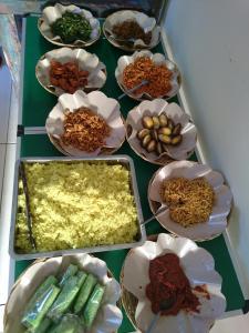una mesa llena de diferentes tipos de alimentos en tazones en Umah Bagus en Sanur