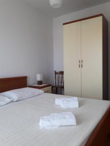 a bedroom with a bed with two towels on it at Apartments Merica in Novalja