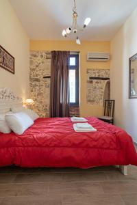 a bedroom with a red bed and a window at Casa Di Silvia in Rethymno Town