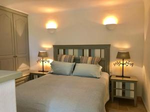 Un dormitorio con una cama grande con dos lámparas encima. en Orangerie St Paul, en Saint-Paul-de-Vence
