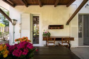 eine Veranda mit einem Holztisch und Blumen darauf in der Unterkunft Trecentolivi B&b in Montignano