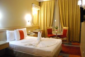 ein Hotelzimmer mit einem Bett und einem Bademantel. in der Unterkunft SV Business Hotel Diyarbakır in Diyarbakır