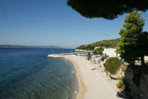 a beach with people and the water and trees at Top Location in Živogošće