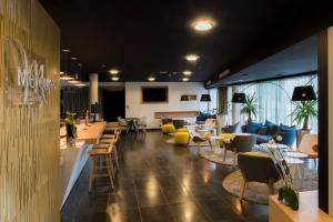 a lobby with couches and tables and chairs at Hôtel Mercure Nantes Ouest Saint-Herblain Zenith in Saint-Herblain