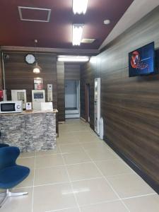an office lobby with a stone counter and a waiting room at Business Hotel Takanoya in Hadano +15 photos
