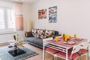 uma sala de estar com uma mesa e um sofá em Modern apartment near Cathedral - BEST LOCATION em Sarajevo