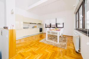 a kitchen with a wooden floor and a white table at LUXURY 3 story House- BEST VIEW in Sarajevo