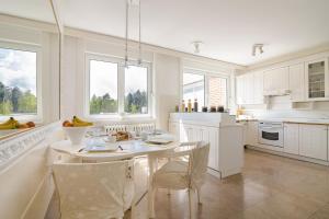 cocina blanca con mesa y sillas en Luxury Stylish Penthouse, en Sarajevo