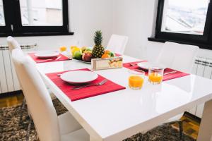 a white table with red napkins and fruit on it at LUXURY 3 story House- BEST VIEW in Sarajevo